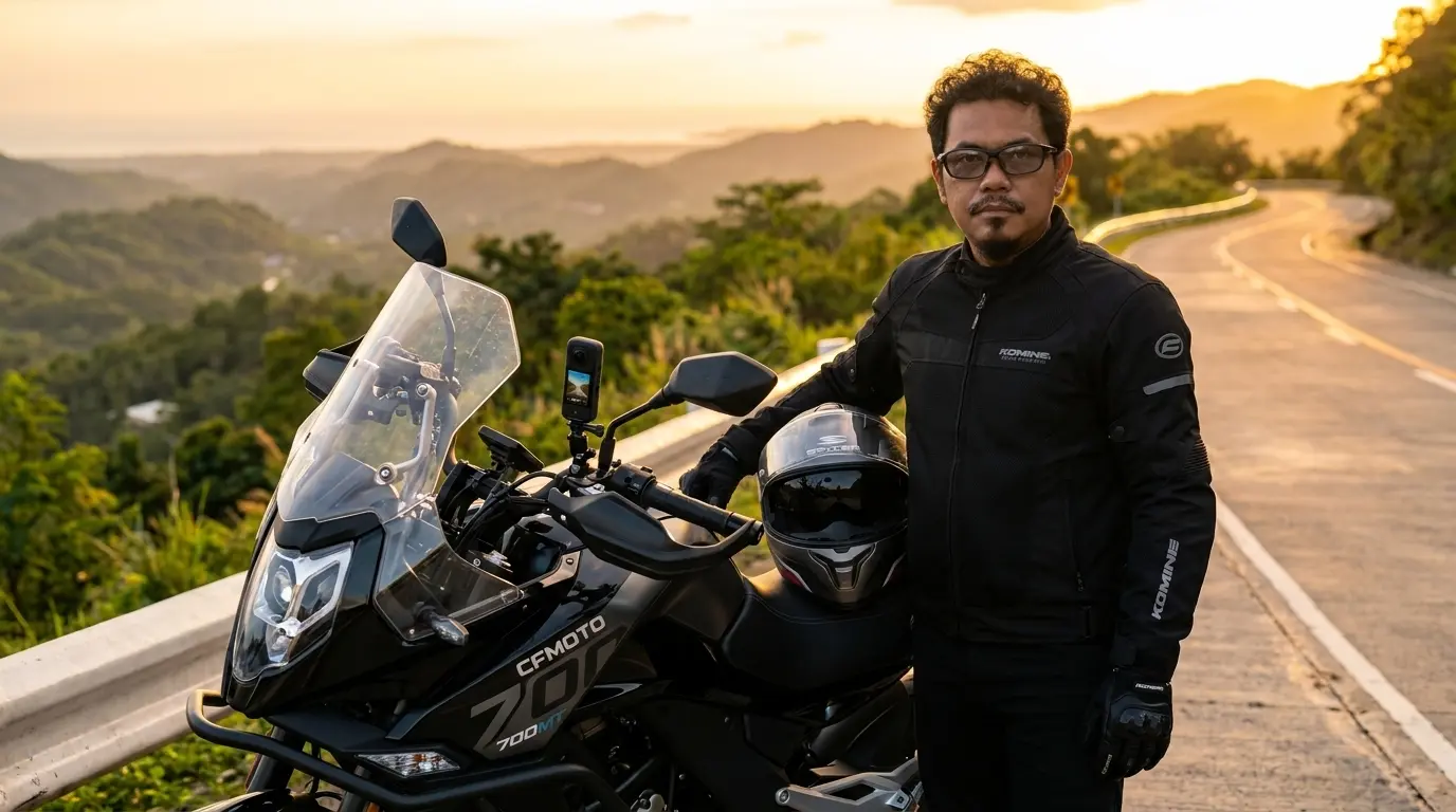 Donald with CFMoto 700MT motorcycle on a mountain road at golden hour